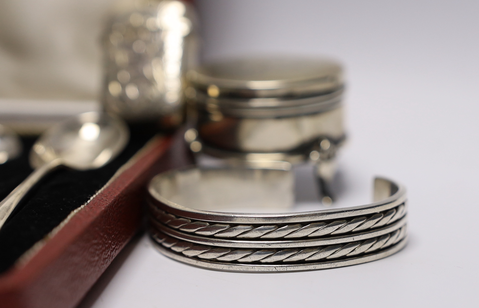 A modern silver caddy spoon, a small Edwardian silver mounted trinket box, a silver vesta case, a Victorian silver bangle and a 925 bangle and a cased set of six silver 'Hallmark' spoons.